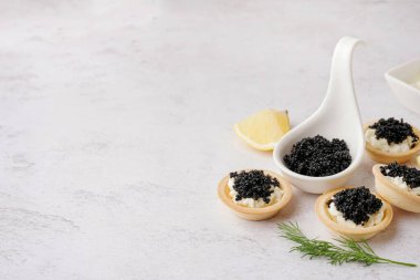 Hafif arka planda siyah havyarlı lezzetli tartlar.