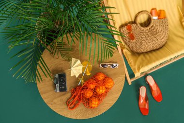 Güverte koltuğu, plaj aksesuarları, palmiye ağacı ve arkaplanda portakallar