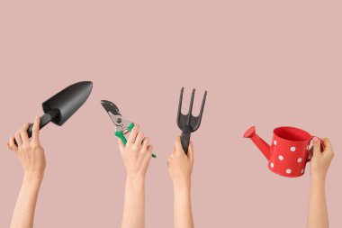 Pembe arka planda farklı bahçe aletleri olan kadınlar.