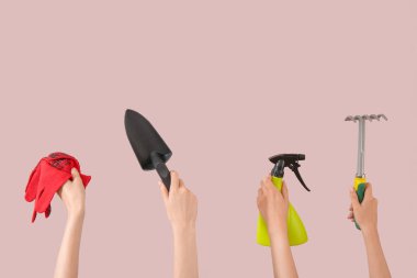 Pembe arka planda farklı bahçe aletleri olan kadınlar.