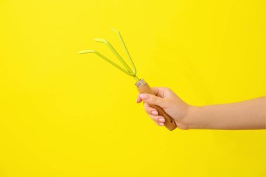 Sarı arka planda bahçıvanlık yapan kadın.