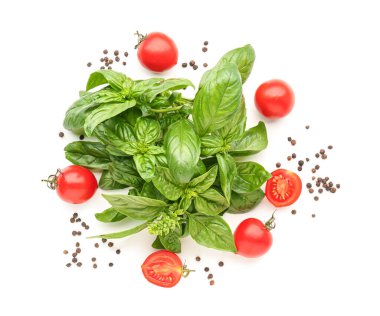 Taze fesleğen, kiraz domatesleri ve beyaz arka planda biber.