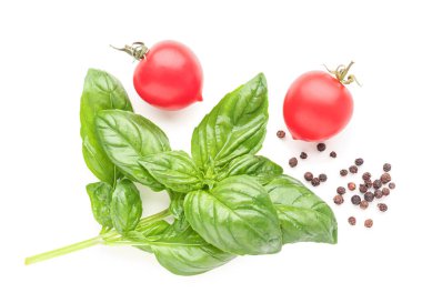 Taze fesleğen, kiraz domatesleri ve beyaz arka planda biber.