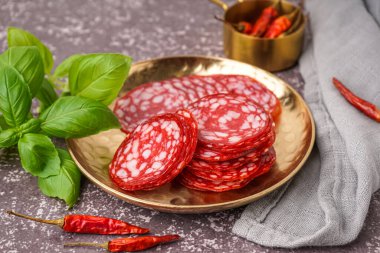 Gri arka planda lezzetli salam dilimleri ile tabak.