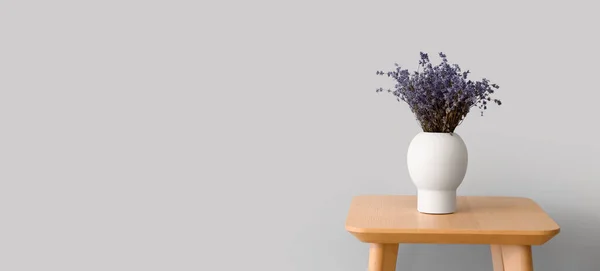 木のテーブルの上に美しいラベンダーの花と花瓶テキストのためのスペースと光の背景 — ストック写真