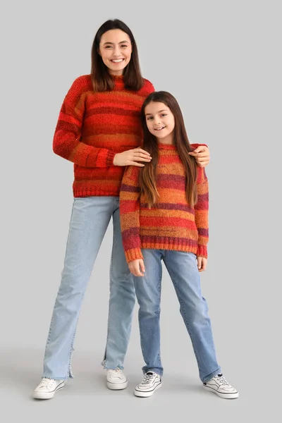 小女孩和她的母亲穿着灰色背景的暖和毛衣 — 图库照片
