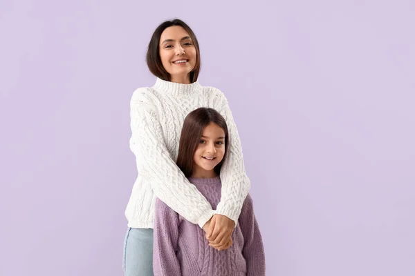 Dziewczynka Jej Matka Ciepłych Swetrach Liliowym Tle — Zdjęcie stockowe