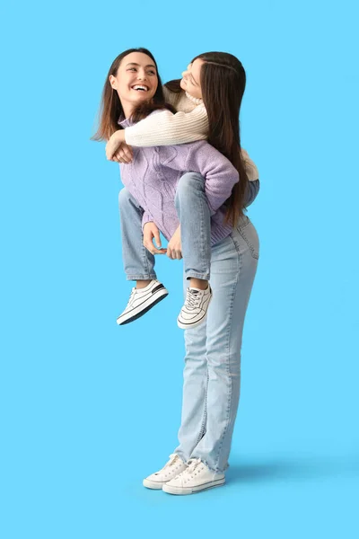 Klein Meisje Haar Moeder Warme Truien Blauwe Achtergrond — Stockfoto