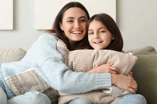 스웨터를 소녀와 어머니 가집에 소파에 베개를 — 스톡 사진