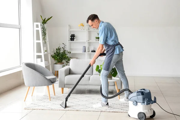 Male Janitor Hoovering Carpet Living Room — Stock Photo, Image