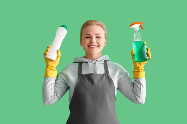 Jonge Vrouw Met Flessen Wasmiddel Groene Achtergrond — Stockfoto
