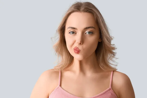 Junge Frau Macht Gesichtsbau Übung Auf Hellem Hintergrund Nahaufnahme — Stockfoto
