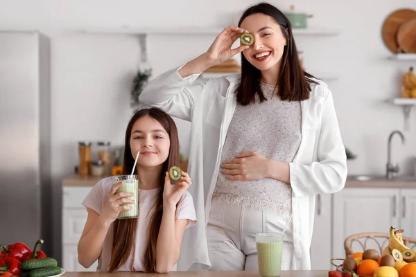 Kleines Mädchen Mit Schwangerer Mutter Trinkt Grünen Smoothie Der Küche — Stockfoto