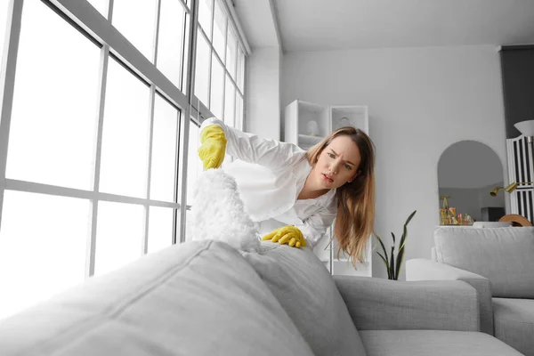 Młoda Kobieta Sprzątanie Sofa Duster Domu — Zdjęcie stockowe