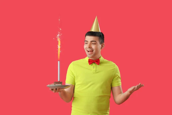 Szczęśliwy Młody Człowiek Tortem Urodzinowym Czerwonym Tle — Zdjęcie stockowe