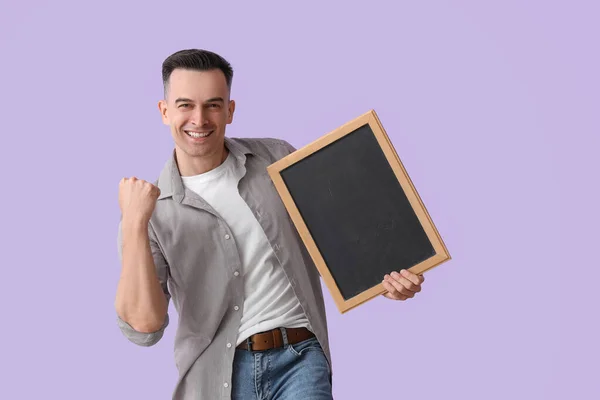 Glücklicher Männlicher Lehrer Mit Kreidetafel Auf Fliederfarbenem Hintergrund — Stockfoto