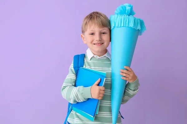 幸せな小さな男の子でバックパック 青学校コーンとノートブック上ライラック背景 — ストック写真