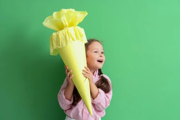 Verrast Klein Meisje Met Gele Schoolkegel Groene Achtergrond — Stockfoto