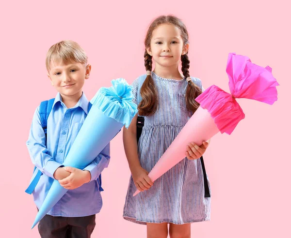 Ευτυχισμένοι Μικροί Συμμαθητές Σακίδια Και Πολύχρωμα Σχολικά Χωνάκια Ροζ Φόντο — Φωτογραφία Αρχείου
