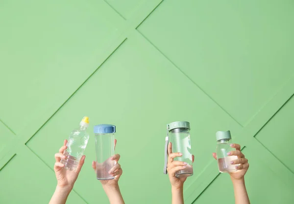 Frauen Halten Sportflaschen Mit Sauberem Wasser Auf Grünem Hintergrund — Stockfoto