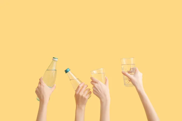 Mulheres Segurando Copos Garrafas Com Água Limpa Fundo Amarelo — Fotografia de Stock