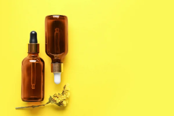 Botol Minyak Esensial Dan Bunga Kering Pada Latar Belakang Kuning — Stok Foto