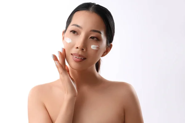 Krásná Asijské Žena Použití Obličejový Krém Proti Bílému Pozadí — Stock fotografie
