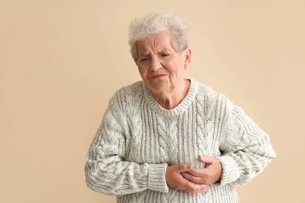Ältere Frau Mit Herzinfarkt Vor Beigem Hintergrund — Stockfoto