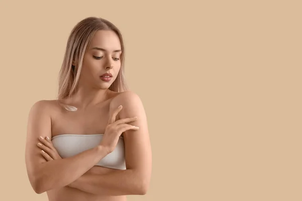 Mooie Jonge Vrouw Met Crème Haar Lichaam Tegen Beige Achtergrond — Stockfoto