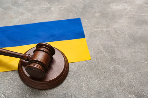 stock image Judge's gavel and flag of Ukraine on grey table