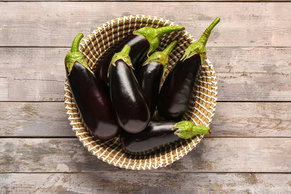 Gri ahşap arka planda taze patlıcan dolu hasır kase.