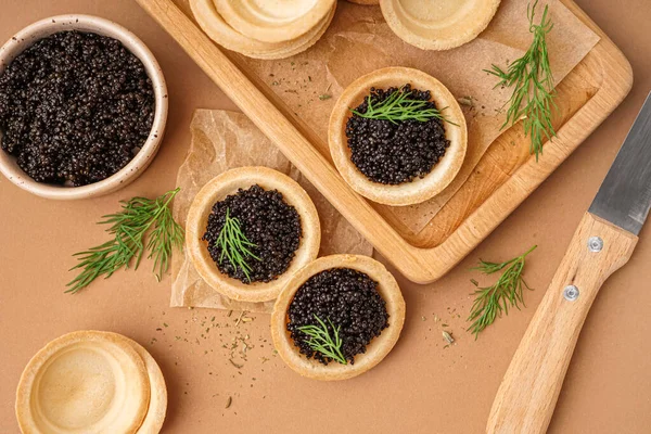 Wooden Board Tasty Tartlets Black Caviar Beige Background — Stock Photo, Image