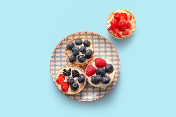 Plate Tasty Tartlets Whipped Cream Berries Blue Background — Stock Photo, Image