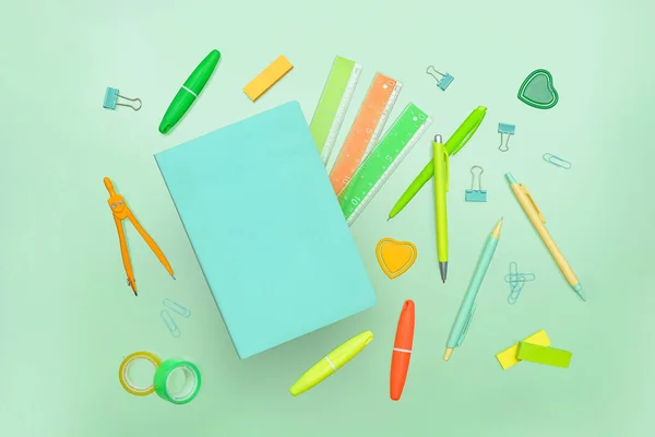 带绿色背景笔记本和学校文具的作文 — 图库照片