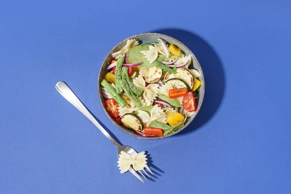 Schaal Van Smakelijke Pasta Salade Met Peper Rode Blauwe Achtergrond — Stockfoto