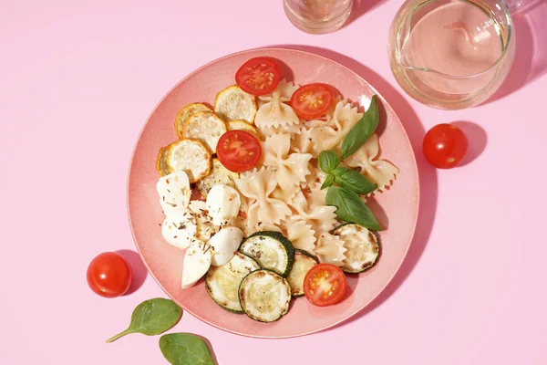 Plaat Van Smakelijke Pasta Salade Met Tomaten Basilicum Roze Achtergrond — Stockfoto