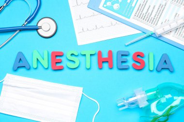 Mavi arka planda tıbbi malzemeler bulunan anestezi söz konusu.