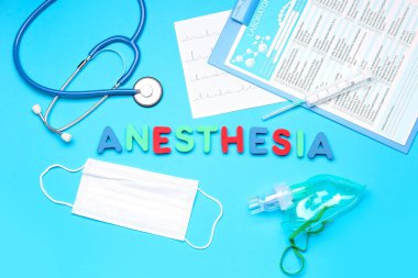 Mavi arka planda tıbbi malzemeler bulunan anestezi söz konusu.