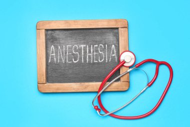 Mavi arka planda anestezi ve steteskop yazılı tebeşir tahtası