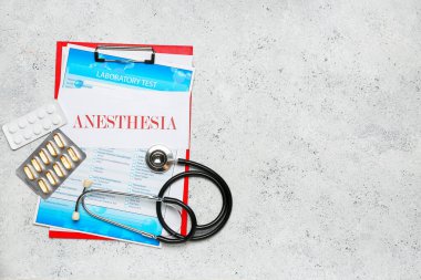 Üzerinde anestezi, hap ve steteskop bulunan bir pano.