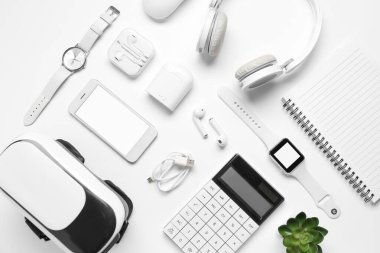 Beyaz zemin üzerinde modern cihazlar ve defter ile kompozisyon
