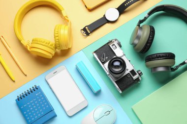 Renk arkaplanı üzerinde farklı aygıtlar ve kırtasiye malzemesi olan kompozisyon