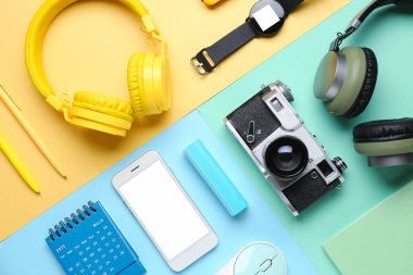 Renk arkaplanı üzerinde farklı aygıtlar ve kırtasiye malzemesi olan kompozisyon