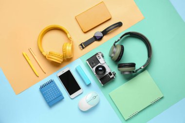 Renk arkaplanı üzerinde farklı aygıtlar ve kırtasiye malzemesi olan kompozisyon