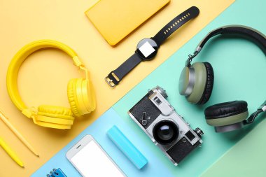 Renk arkaplanı üzerinde farklı aygıtlar ve kırtasiye malzemesi olan kompozisyon