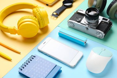 Renk arkaplanı üzerinde farklı aygıtlar ve kırtasiye malzemesi olan kompozisyon