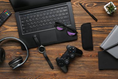 Ahşap zemin üzerinde modern cihazlar, gözlükler ve kırtasiye malzemesi ile kompozisyon