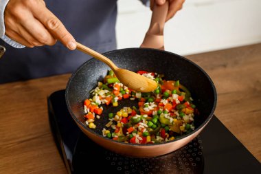 Mutfakta sebze kızartan genç adam, yakın plan.