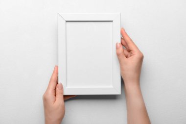 Beyaz arkaplanda boş fotoğraf çerçevesi tutan kadın