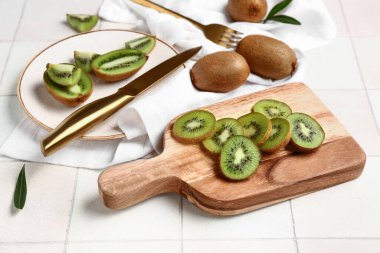 Tahta levha ve tabakta beyaz fayanslı taze kivi dilimleri.